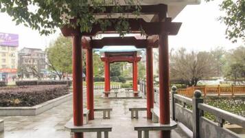 A traditional Japanese pavilion with a roof, benches, and a stone pathway.