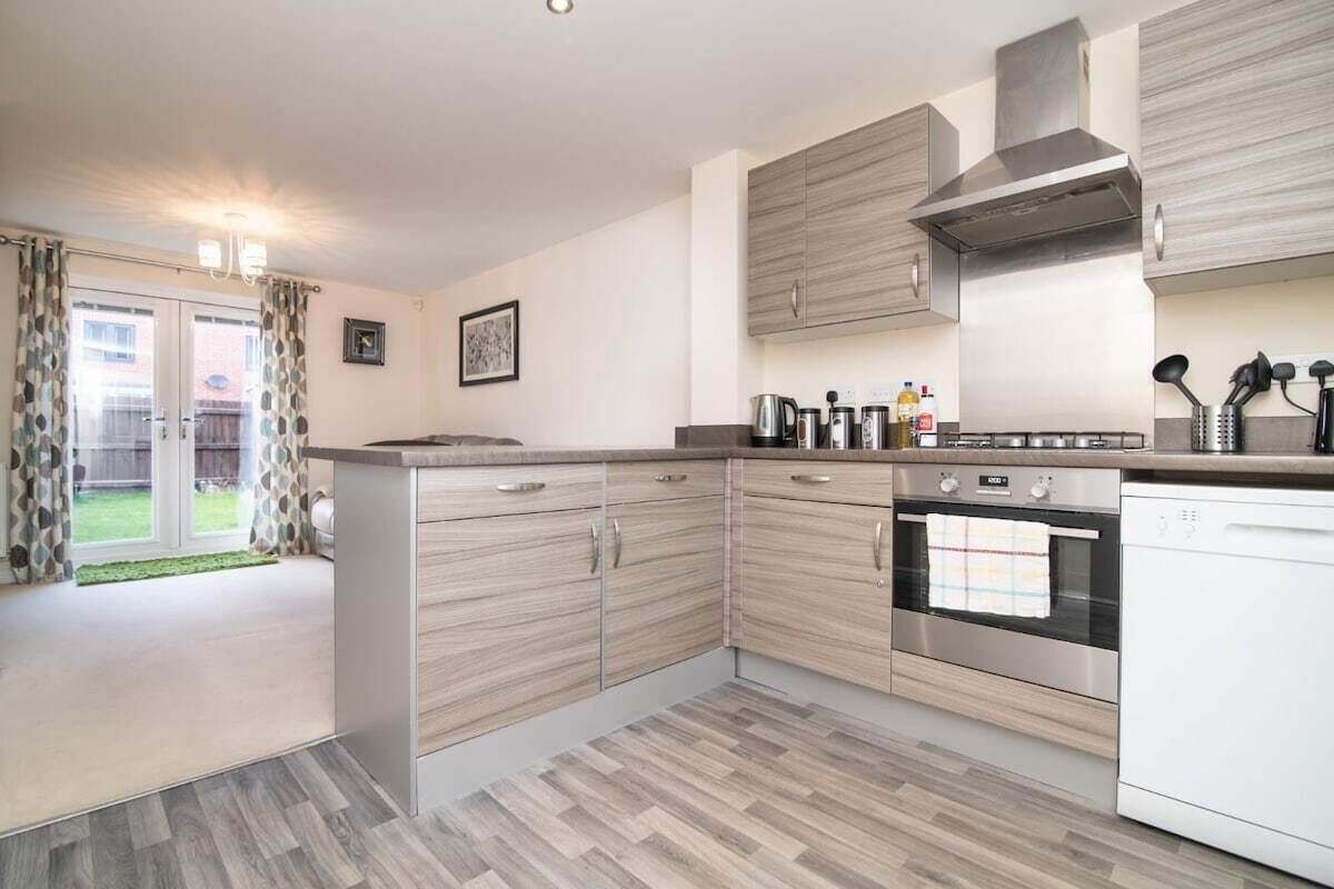 A modern kitchen with wooden cabinets, a built-in oven, and a dishwasher.