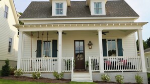A two-story house with a porch, a front door, and a small balcony.