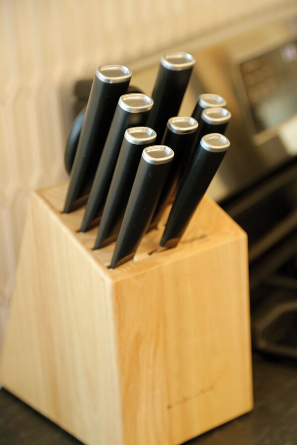 A wooden knife block with several knives inserted.