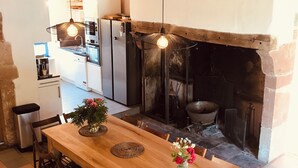 Eine rustikale Küche mit einem Holztisch, Stühlen und einem Kamin.