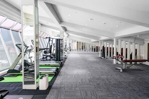 A gym with cardio machines, weightlifting equipment, and a mirrored wall. - Cheng Wan Grand Hotel (Nantou)