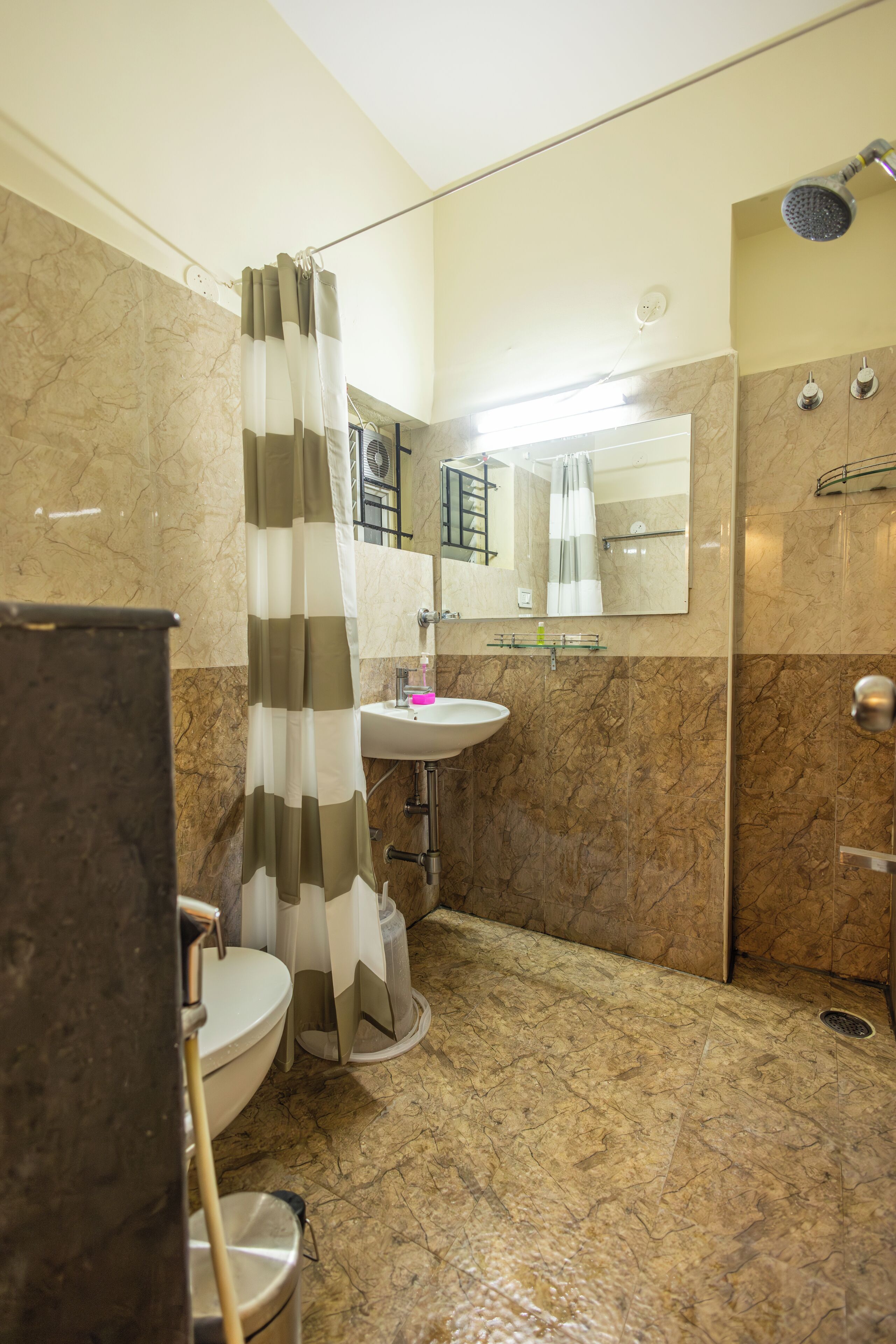 A bathroom with a toilet, sink, and shower.