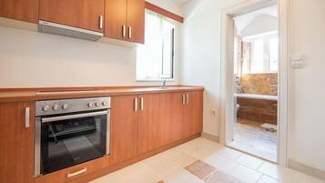 A kitchen with wooden cabinets, a built-in oven, and a window.