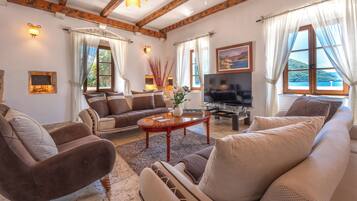 Una sala de estar acogedora con un conjunto de sofás, una mesa de centro y un televisor.