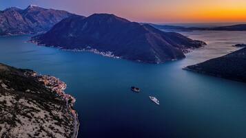 A coastal landscape with mountains, a body of water, and a small town.
