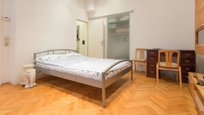 A bedroom with a bed, a chair, a desk, and a wardrobe. - Nice 1-bedroom apartment in Wien with WiFi (Wien)
