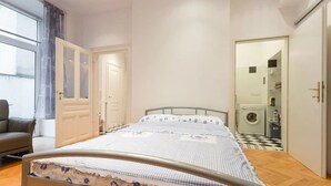 A bedroom with a bed, a chair, a wardrobe, and a washing machine. - Nice 1-bedroom apartment in Wien with WiFi (Wien)