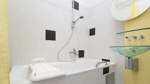 A modern bathroom with a white bathtub, a glass-faceted sink, and a showerhead. - Nice 1-bedroom apartment in Wien with WiFi (Wien)