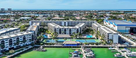 A hotel with a central courtyard, multiple swimming pools, and a marina with boats.
