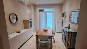 A compact kitchen with a dining table, chairs, and a cabinet. - Marina Romea 2 Splitted Executive Flats (Ravenna)