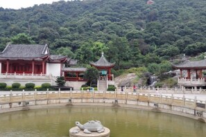 A traditional Chinese building with a pond and a bridge.