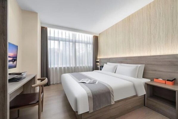 Una habitación de hotel con una cama, un escritorio con silla, televisión y ventana con cortinas.