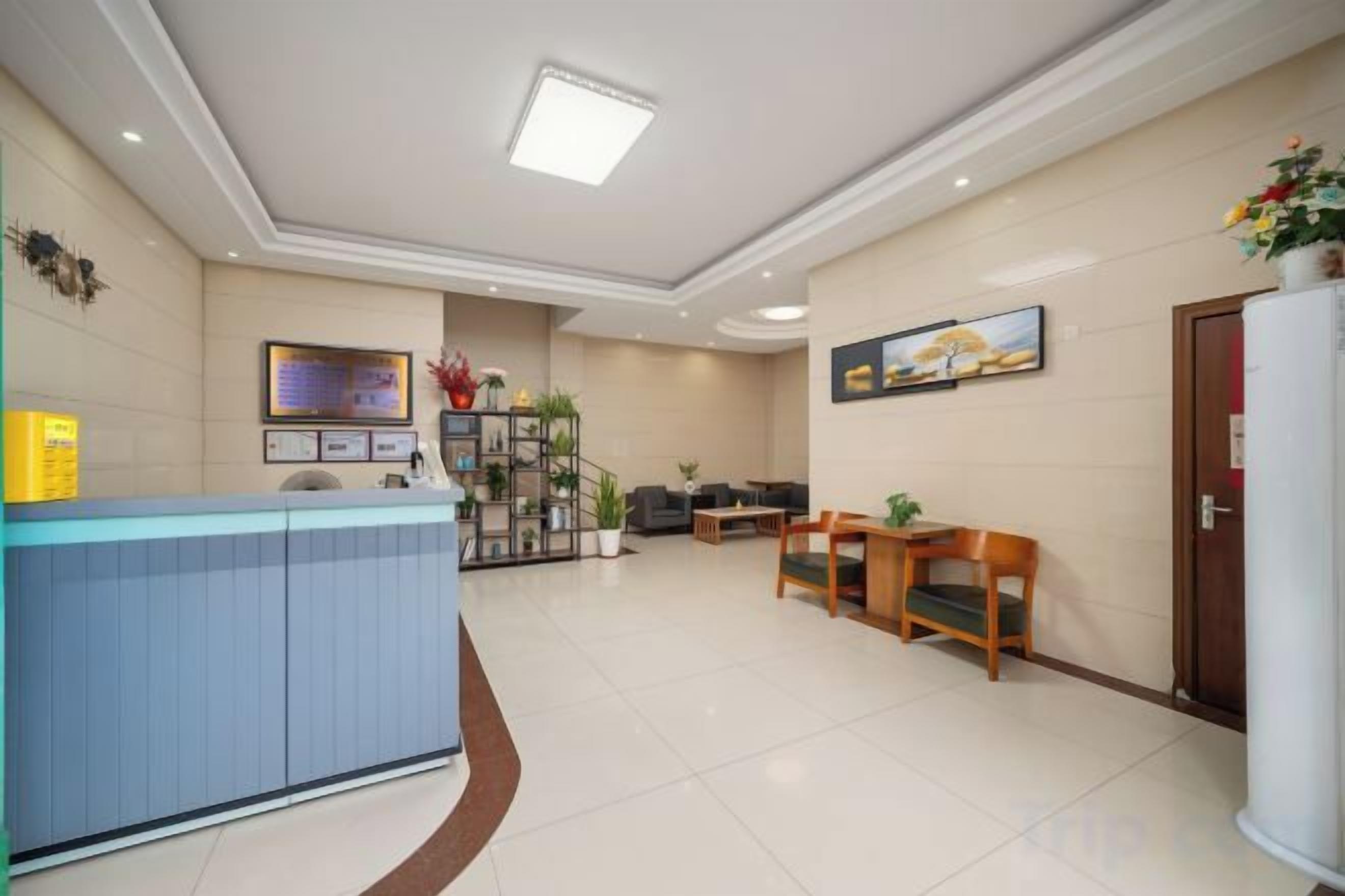 Un hall d’hôtel comprenant un comptoir d’accueil, un espace salon et un escalier menant à l’étage supérieur.