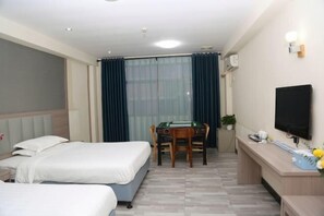 A hotel room with two beds, a desk with a computer, a television, and a window with curtains. - Shenzhen Liuliu Hotel (Shiyan Bus Station) (Shenzhen)