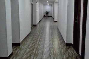 A long, narrow hallway with a patterned floor and white walls. - Shenzhen Liuliu Hotel (Shiyan Bus Station) (Shenzhen)