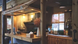 Una cocina rústica con vigas de madera, una barra, taburetes y un ventanal con vistas.