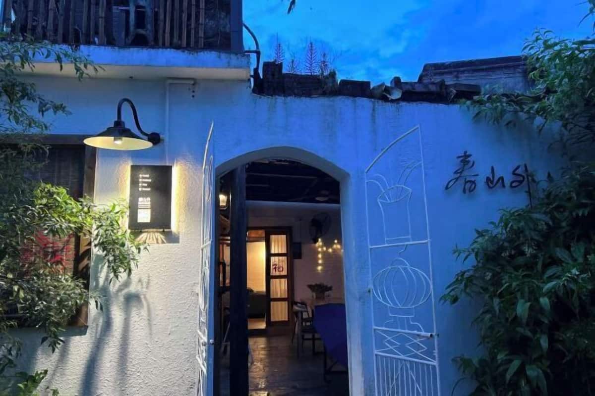 Una entrada con una reja, una lámpara y un muro decorado.