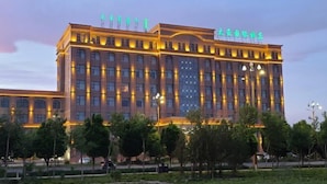 A large, multi-story hotel with a modern design, featuring a prominent entrance and illuminated signage.