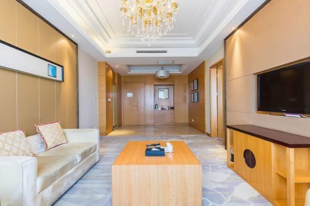 Un vestíbulo de hotel con un sofá, una mesa de centro, televisor y paneles de madera.