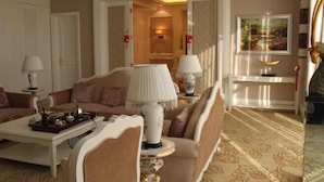 A well-appointed hotel room with a sofa set, a coffee table, and a lamp.