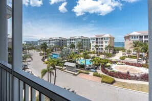 A resort with multiple buildings, a swimming pool, and a view of the ocean.
