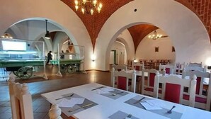 A restaurant with high arched brick ceilings, white tables with menus, and red cushioned chairs. - Hôtel Écrin hamammet  (Hammamet)