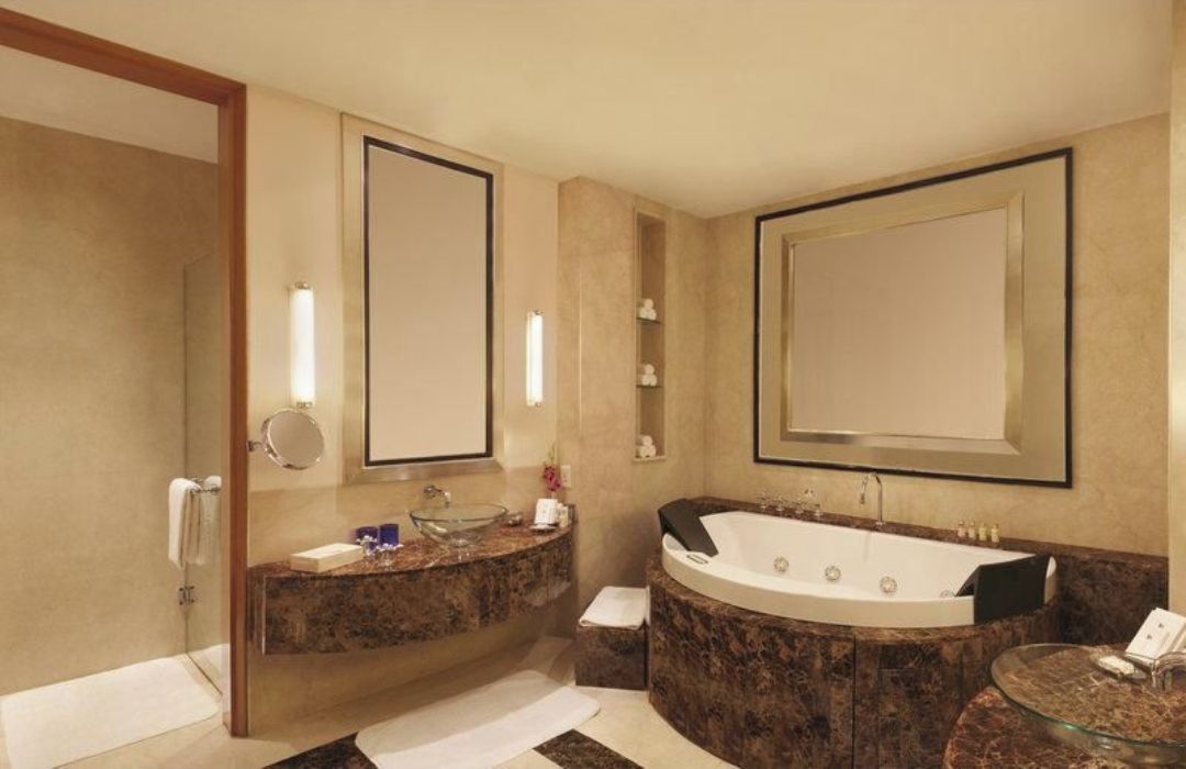 Un baño moderno con una bañera grande, un lavabo doble y un box de ducha de vidrio.