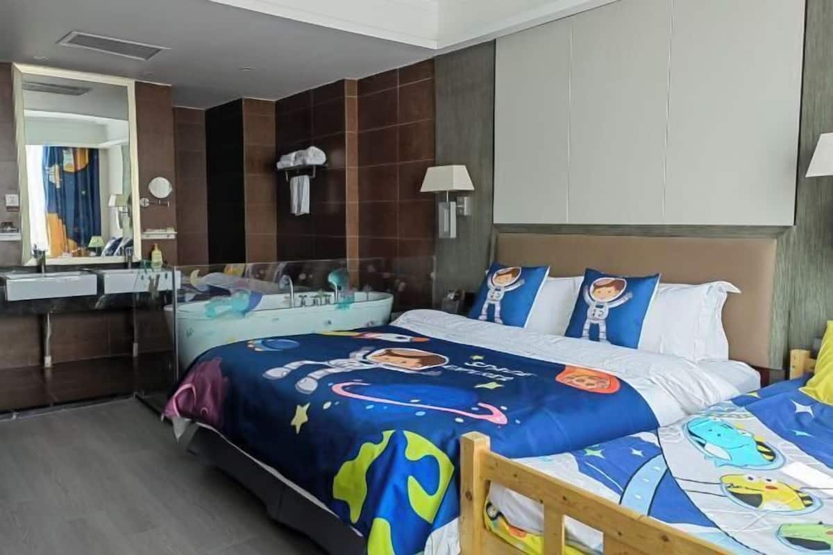 A hotel room with a large bed, a wooden chair, a vanity with a mirror, and a bathtub.