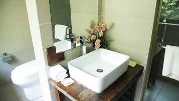 A bathroom with a white sink, mirror, and toilet.