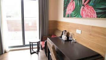 A dining area with a table, chairs, a painting of flamingos, and a sliding glass door leading to an outdoor area.