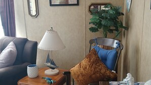 A living room with a sofa, armchair, side table, lamp, and decorative items. - Handicap Accessible Private Spacious Beautiful Family Home 5 Acres Pet Friendly  (Homosassa)
