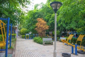 An outdoor area with exercise equipment, a lamp post, and greenery. - Loushanglou Seascape Motel (Sanya)