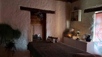Cozy retreat with a plush bed, sitting area, and exposed brick walls.