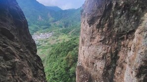 A narrow canyon with steep rock walls and a village below. - Youran Inn (Yueqing)