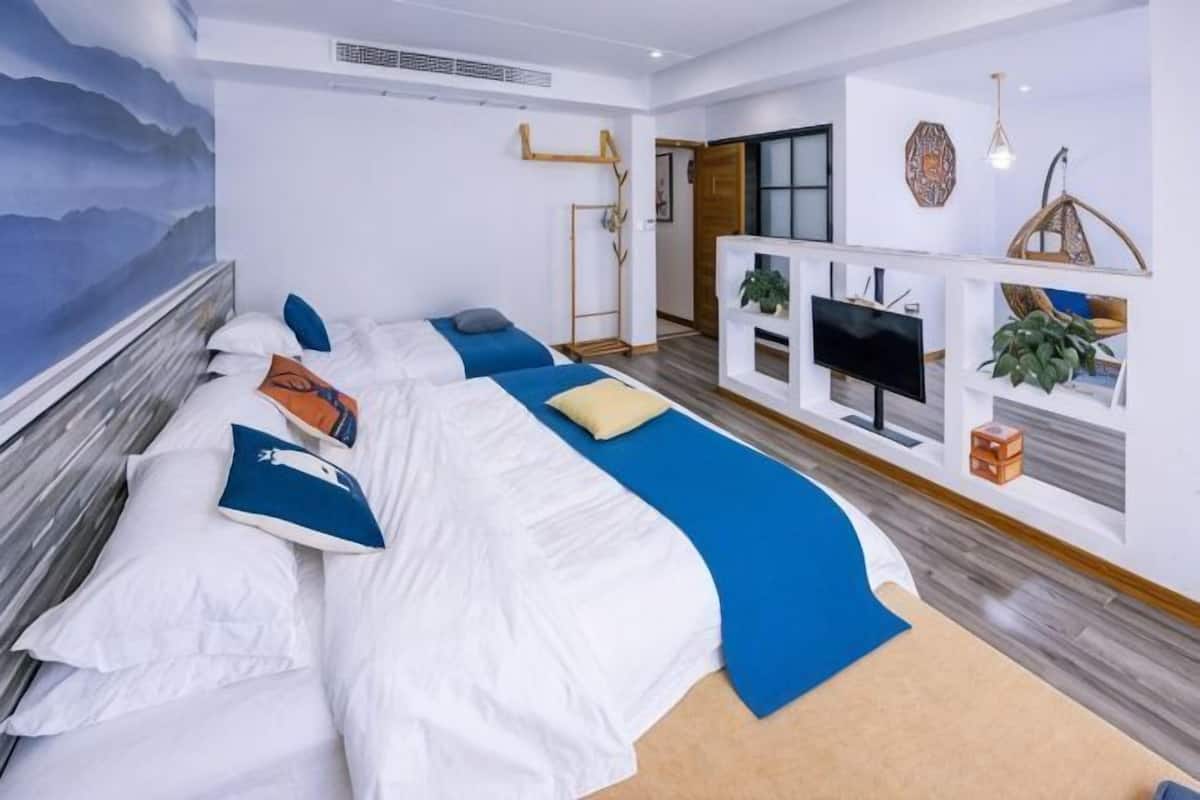 A modern hotel room with a large bed, a TV, and a desk area.