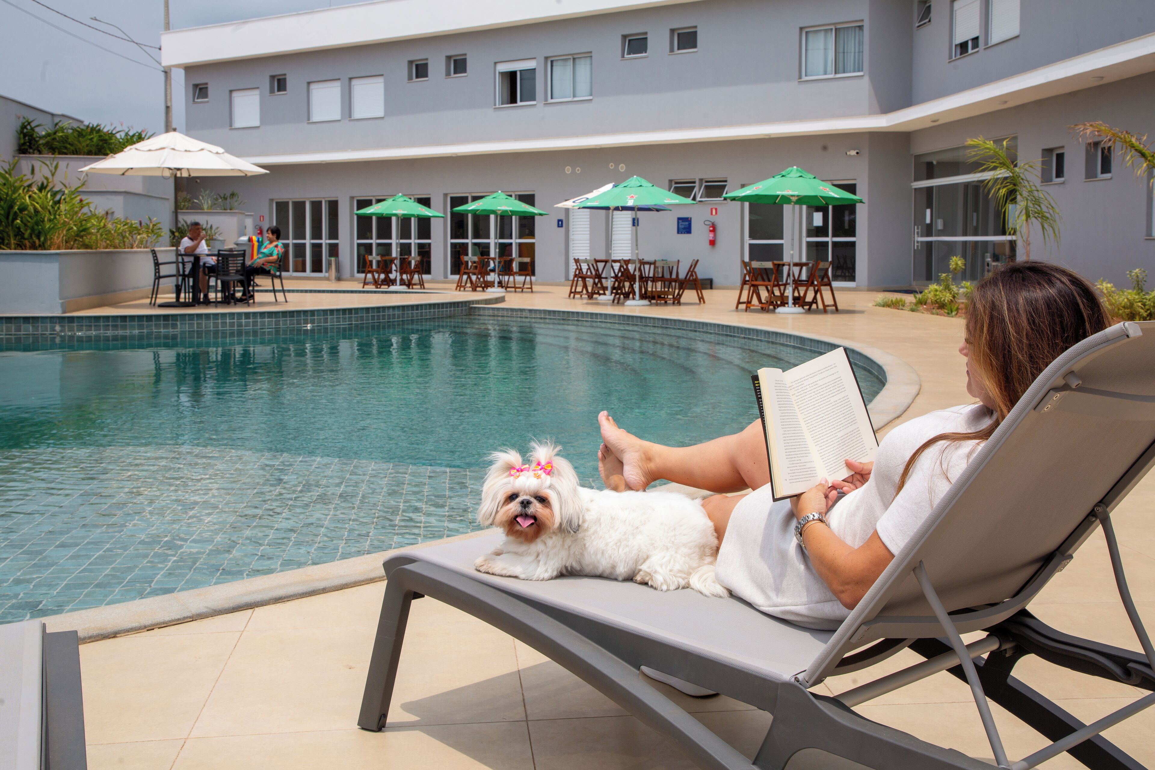 Ein Poolbereich mit Liegestühlen, Sonnenschirmen und einem kleinen Pool.