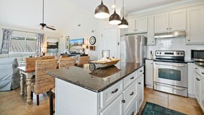 A modern kitchen with white cabinets, stainless steel appliances, and a central island. - Bear Point 3BR House Orange Beach Bring Your Boat! (Orange Beach)