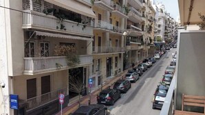 A multi-story residential building with balconies, parked cars, and a pedestrian walkway. - Athenian Center Athens Kolonaki (Athina)