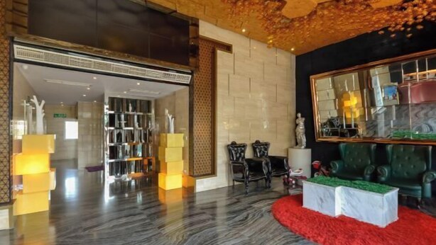 A lobby with a marble floor, a red carpet, and a large mirror reflecting the interior. - Pugongying Hotel (Yuhuan)