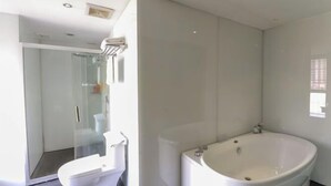 A modern bathroom with a glass-enclosed shower, a toilet, and a freestanding bathtub. - Pugongying Hotel (Yuhuan)