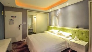 A hotel room with a bed, bedside table, and a wall-mounted phone. - Pugongying Hotel (Yuhuan)
