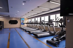 A gym with multiple treadmills and elliptical machines arranged in rows. - Shaanxi Iron and Steel Building (Xi'an)