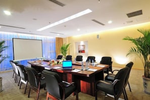 A conference room with a long table, chairs, a projector screen, and a laptop. - Shaanxi Iron and Steel Building (Xi'an)