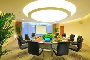 A conference room with a round table, black chairs, a laptop, and a projector screen. - Shaanxi Iron and Steel Building (Xi'an)