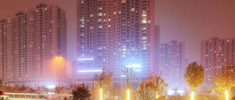 A parking lot with multiple cars and high-rise buildings in the background.