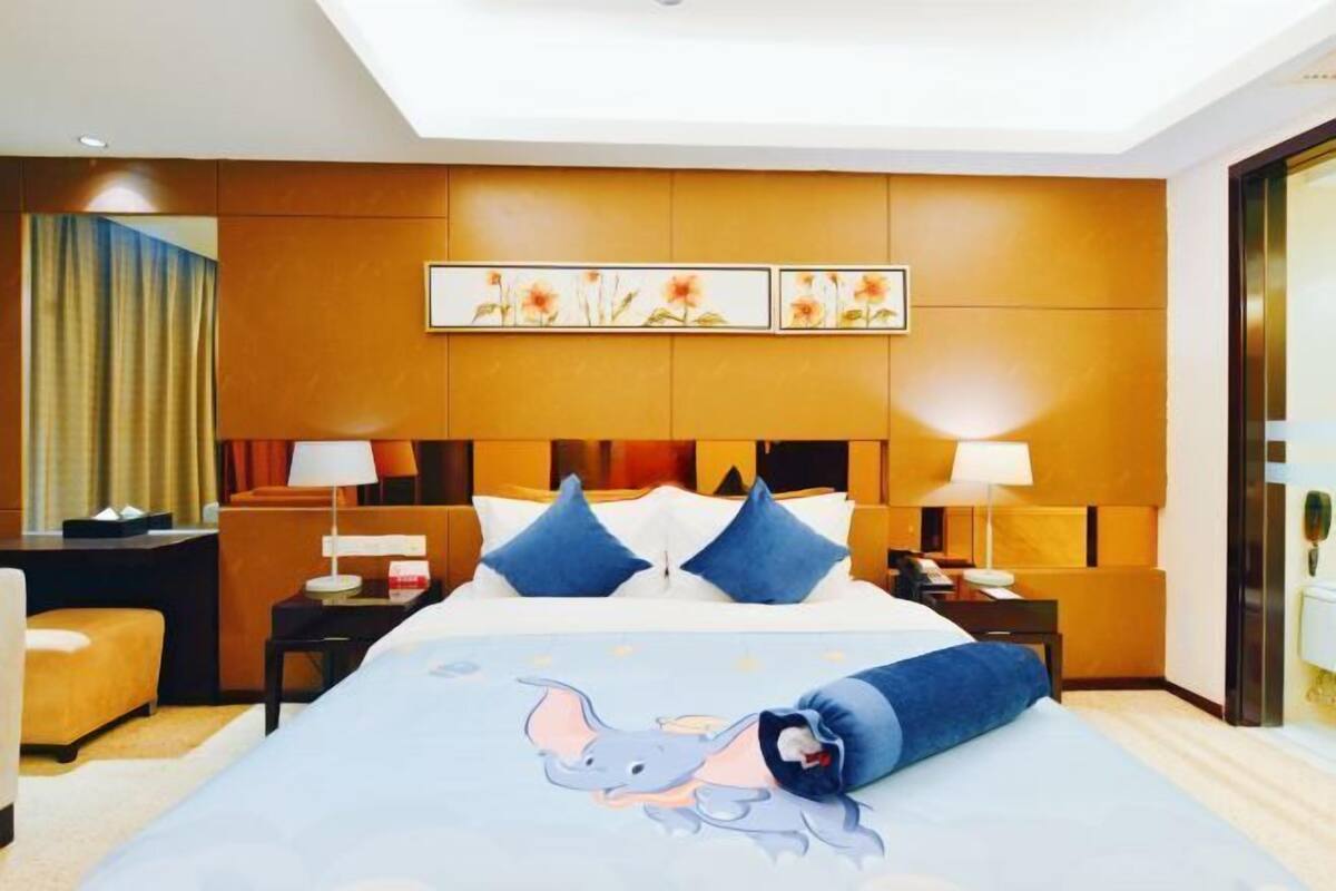 A hotel room with a large bed, two bedside tables, a desk, and a chair.