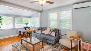 Ein Wohnzimmer mit Sofa, Couchtisch und Deckenventilator.