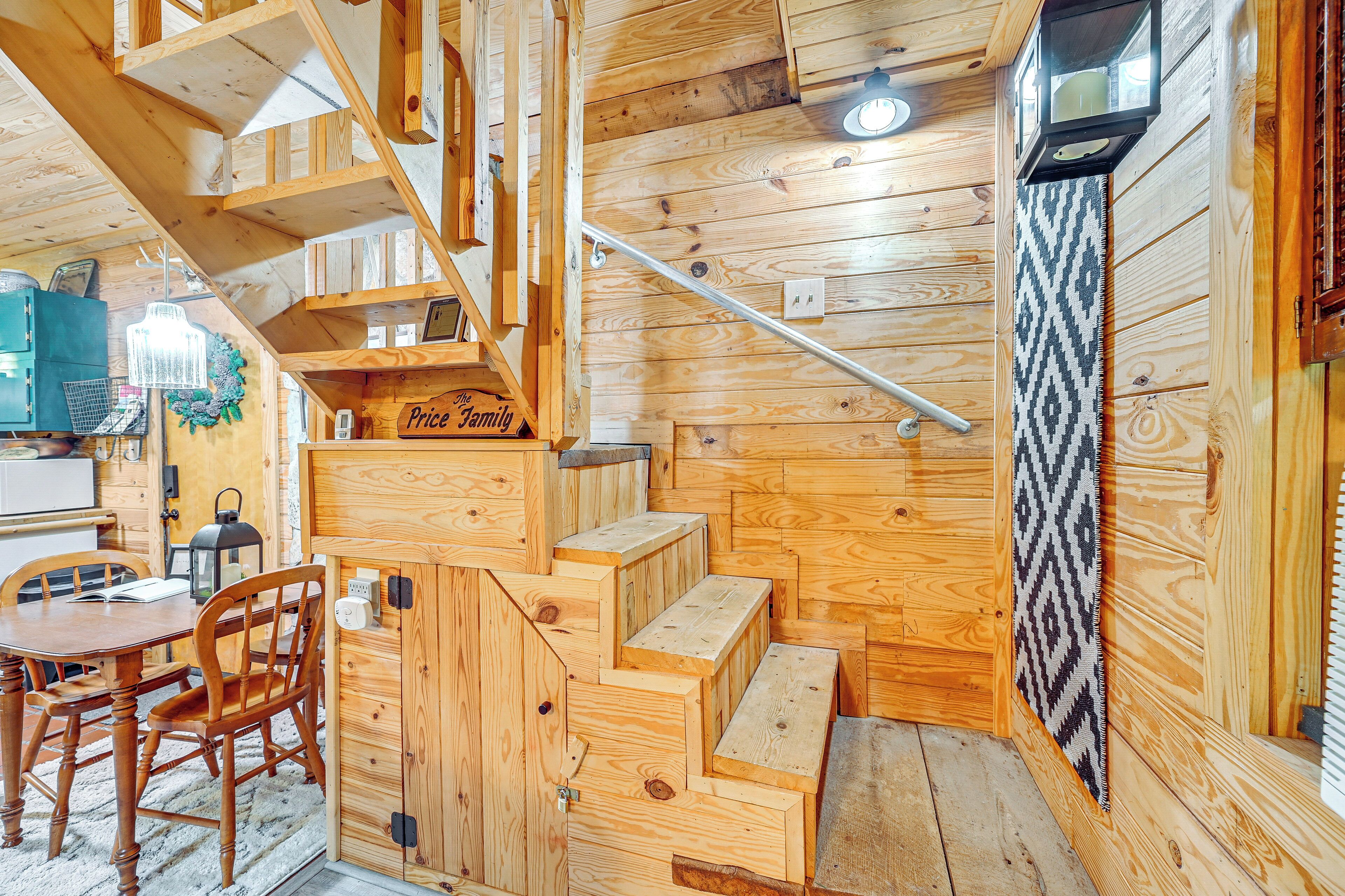 A wooden interior with a staircase, a dining table with chairs, and a sign that reads "Price Family".