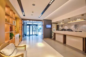 A reception area with a reception desk, a waiting area with chairs, and a wall-mounted TV.